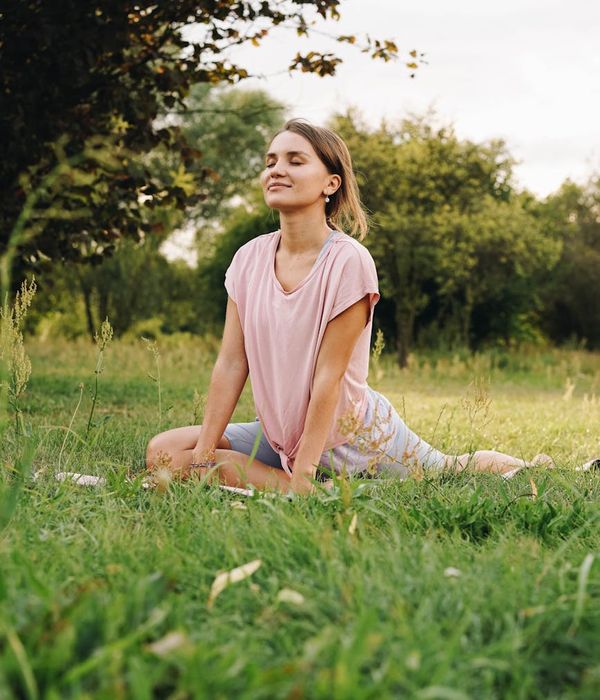 Woman practicing mindful breathing outdoors with a calm expression.